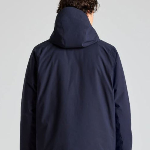 Person wearing a navy blue hooded jacket on a light gray background