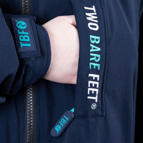 Navy jacket with 'Two Bare Feet' branding on a black background