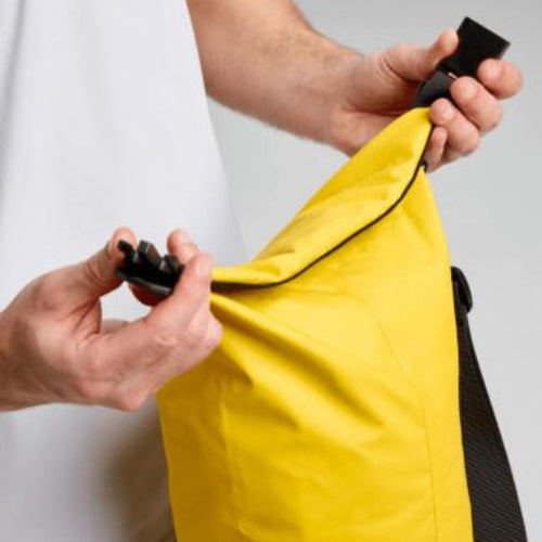 Person holding a yellow jacket with black zippers against a white background