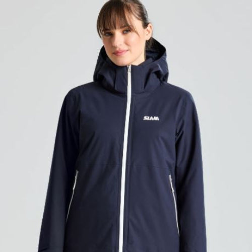 Woman wearing a navy blue jacket with a brand logo on a light gray background