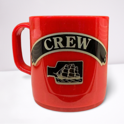 Red unbreakable mug, featuring black and gold accents of the word crew and a ship in a bottle.