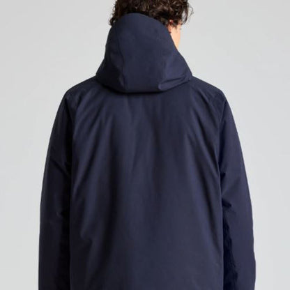 Person wearing a navy blue hooded jacket on a light gray background