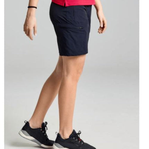 Person wearing navy shorts and black shoes on a light gray background