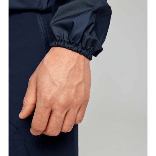 Water-repellent SLAM ACT Packlite Jacket with spacious side pockets and adjustable hood for outdoor activities.